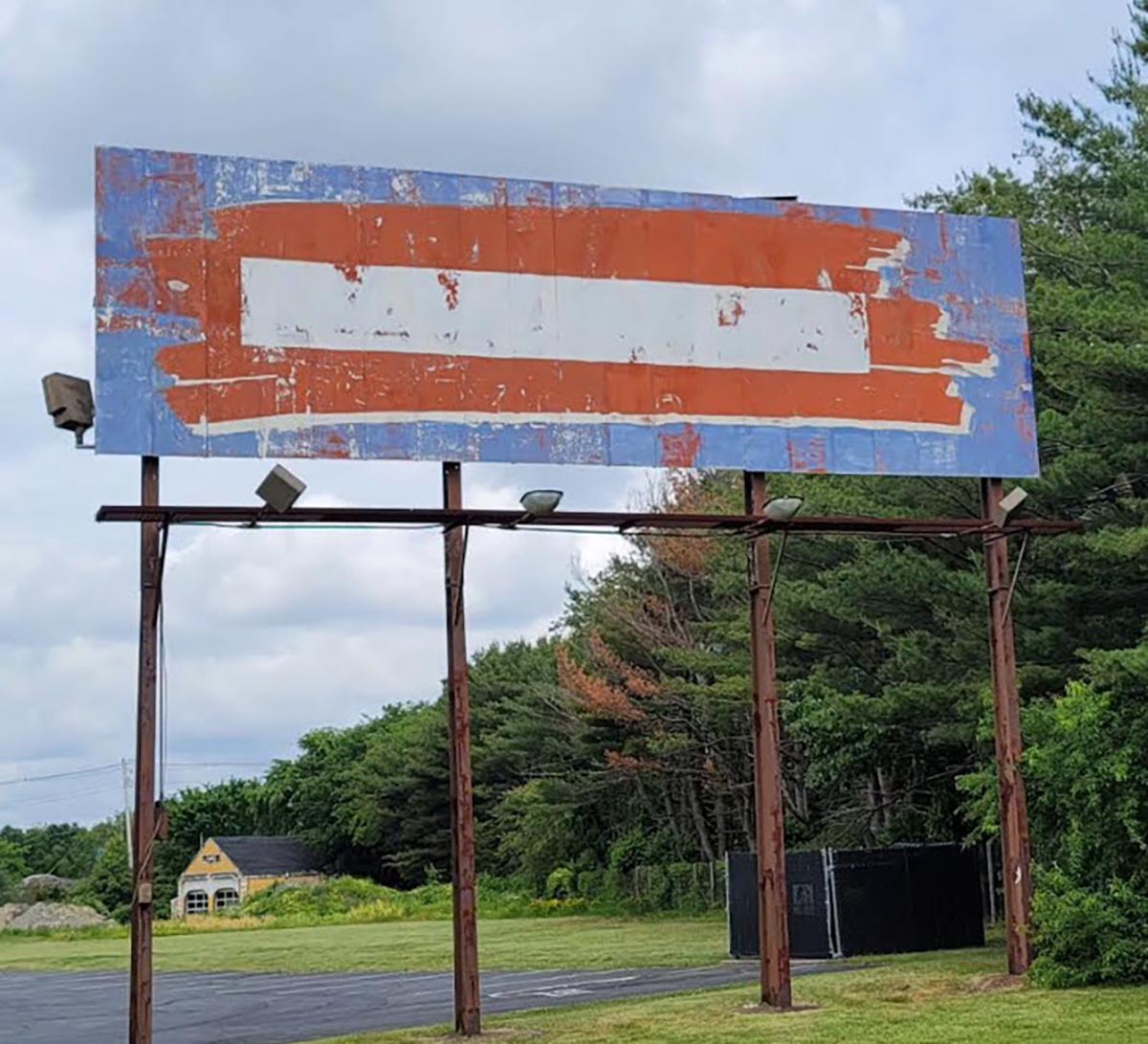 A billboard awash with color. Blue, red, then white lay on top of each other. The colors pull one in with intrigue despite surely being laid down haphazardly.